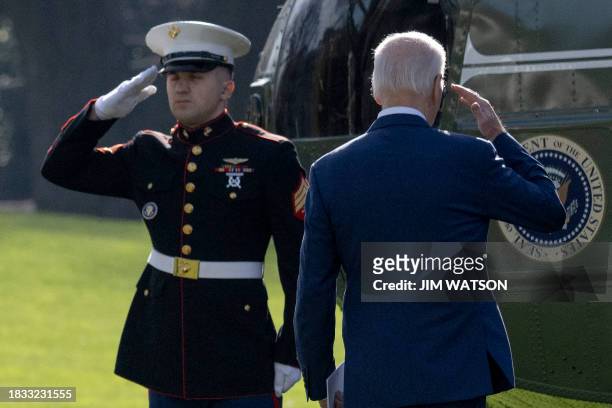 President Joe Biden salutes while boarding Marine One on the South Lawn of the White House in Washington, DC, on December 8, 2023. Biden will travel...