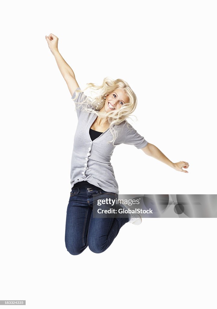 A woman jumping into the air with her hands up