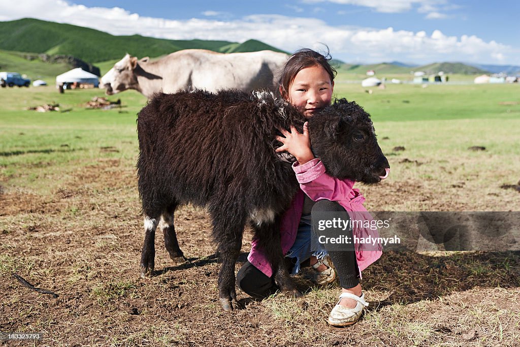 Mongolian young girl playing with yak