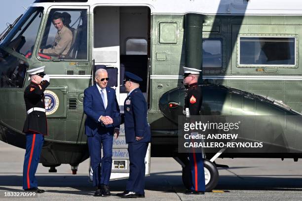 President Joe Biden shakes hands with Colonel Paul Pawluk , 89th Airlift Vice Wing Commander, prior to boarding Air Force One at Joint Base Andrews...