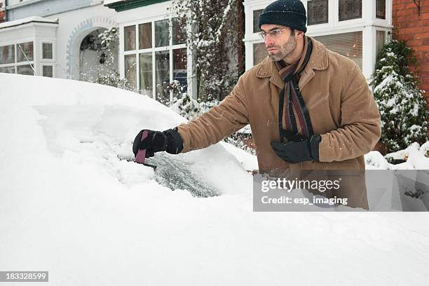 mann ausführen schnee von einem auto windschutzscheibe - scraping stock-fotos und bilder