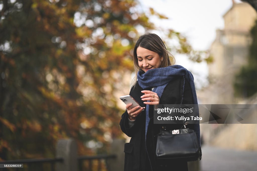 Lächelnde mittlere erwachsene Frau Online-Messaging im Freien.