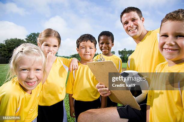 soccer coach with team of young children - portrait of school children and female teacher in field stock pictures, royalty-free photos & images