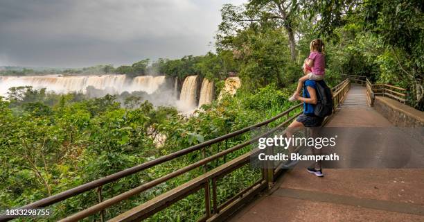 madre e hija disfrutando de las impresionantes cataratas del iguazú en el parque nacional iguazú en la frontera de argentina y brasil, américa del sur - garganta del diablo fotografías e imágenes de stock