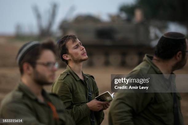 Israeli soldiers pray near the border with the Gaza Strip on December 8, 2023 in southern Israel. Israel and Hamas have resumed fighting after the...