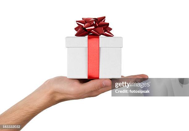 close-up of hand holding up white gift box with red ribbon - gift hand stock pictures, royalty-free photos & images