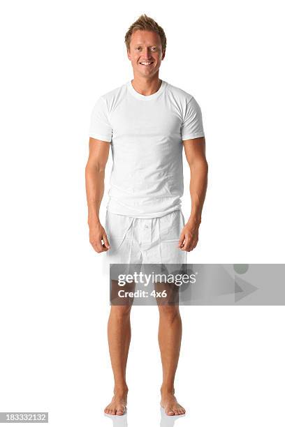 isolated man standing in white shirt and boxers - white shorts stockfoto's en -beelden