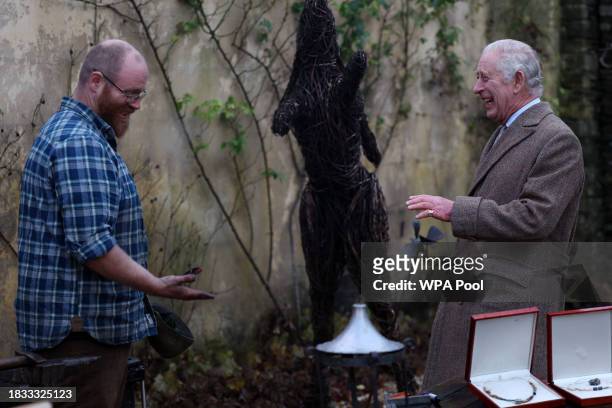 King Charles III speaks with Ian Thackray , a blacksmith who's hands were too dirty to shake hands with the King, during a festive themed...