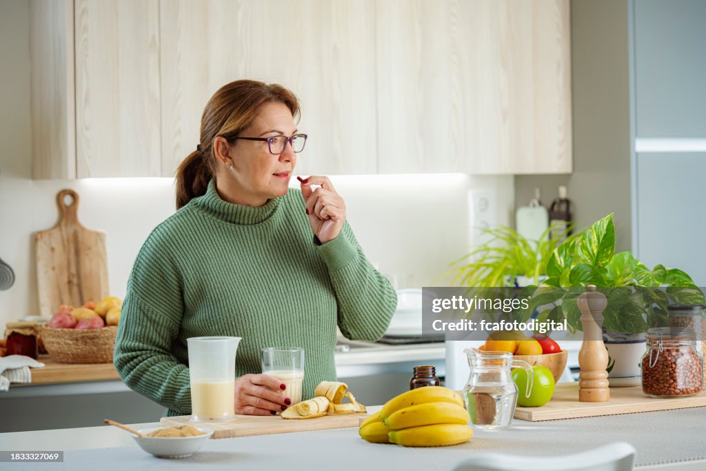 Mature woman taking dietary supplement pill