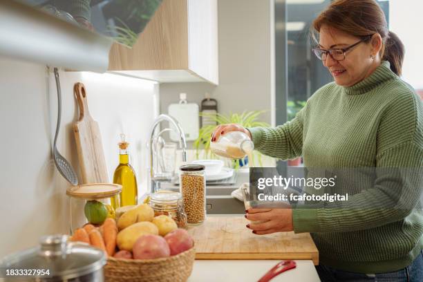 mature woman pouring fresh soy milk - rauwe melk stockfoto's en -beelden