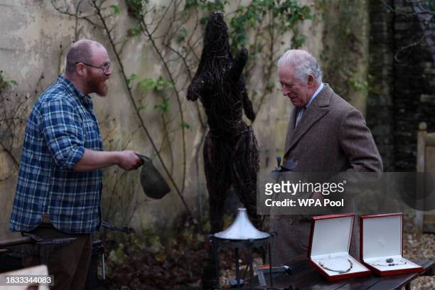 King Charles III speaks with Ian Thackray , a blacksmith who's hands were too dirty to shake hands with the King, during a festive themed...