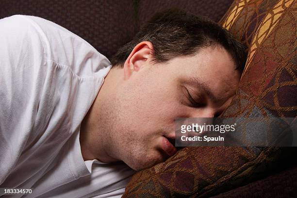 schlafen auf der couch - schnarchen mann stock-fotos und bilder