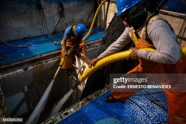 Port workers unload anchovy to be processed and converted into fishmeal after the offshore fishing task beyond 5 miles in the department of Lima on...