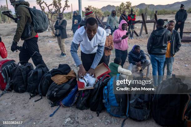 An immigrant from Mauritania repacks a new pair of Pumas after crossing the U.S.-Mexico border on December 05, 2023 in Lukeville, Arizona. A surge of...