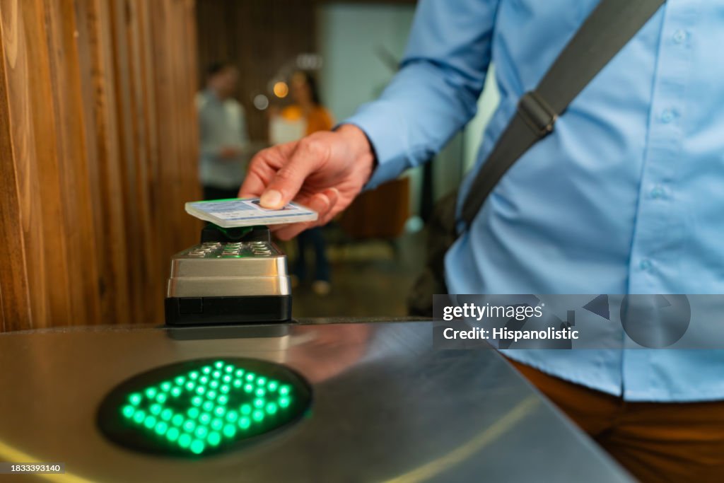 Close-up on a man entering a building and scanning his ID card at the door