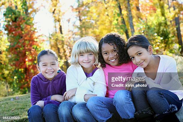 cuatro chicas en el parque - sólo niñas fotografías e imágenes de stock
