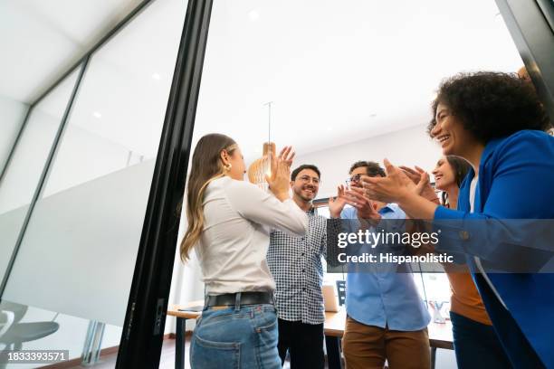 une équipe d’affaires heureuse qui célèbre une réussite au bureau - réjouissances photos et images de collection