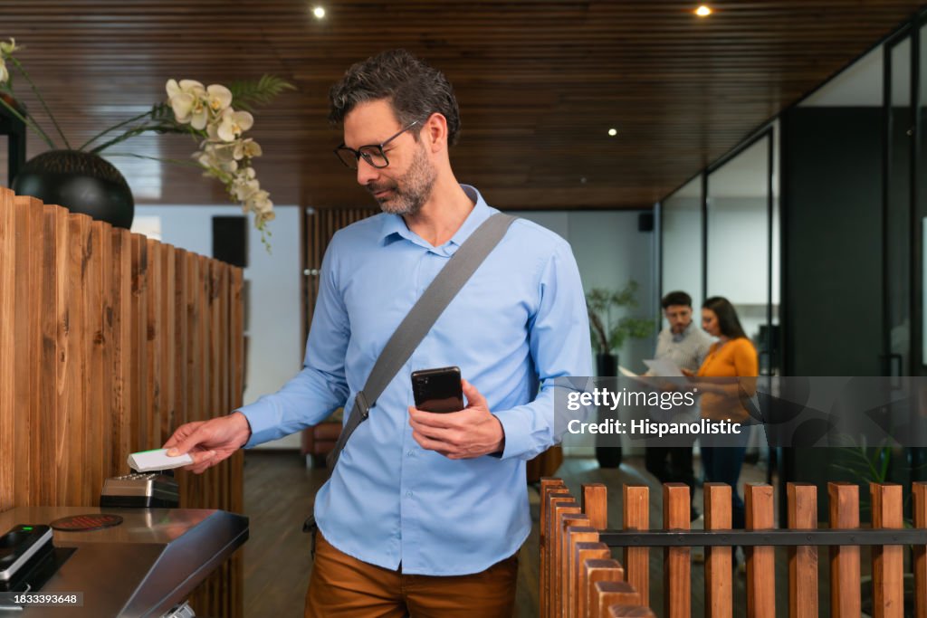 Geschäftsmann verlässt das Büro und scannt seine Karte an der Tür