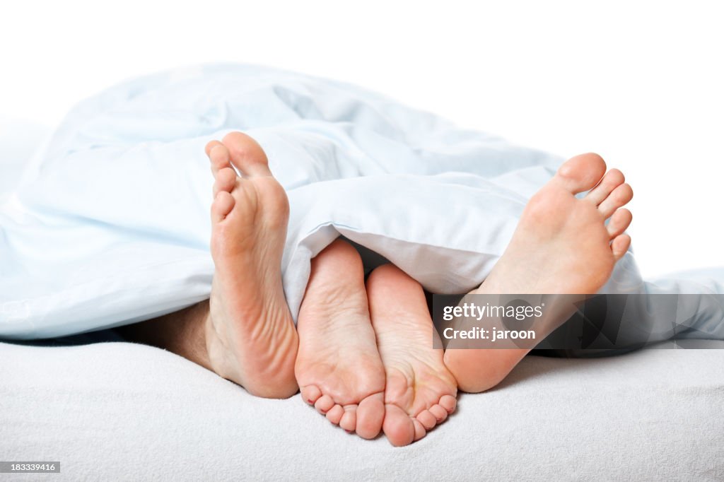 Young couple feet in bed