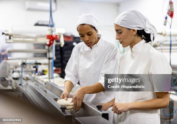 supervisor training a new worker at an industrial bakery - chefs whites stock pictures, royalty-free photos & images