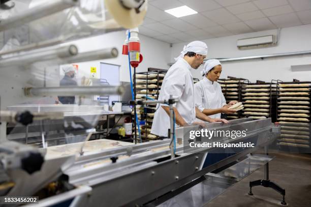 foreman training a new worker at an industrial bakery - bread packet stock pictures, royalty-free photos & images
