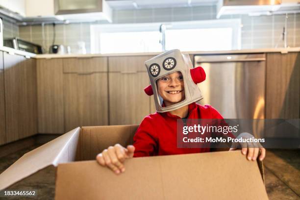 young boy in robot costume playing in cardboard box - vestuario teatral fotografías e imágenes de stock