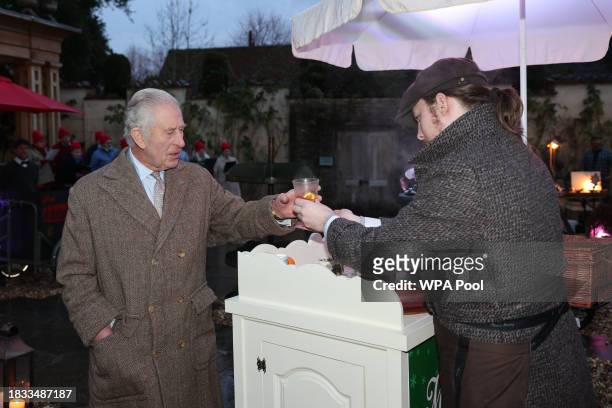 King Charles III is given a glass of mulled cider to taste during a festive themed 'Celebration of Craft' at Highgrove House on December 8, 2023 in...