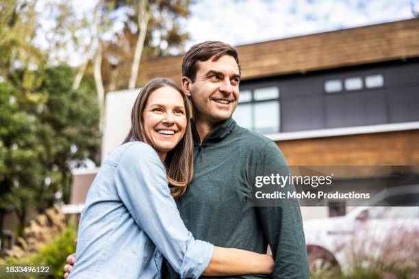 portrait of married couple in front of modern home - couple before marriage stock-fotos und bilder