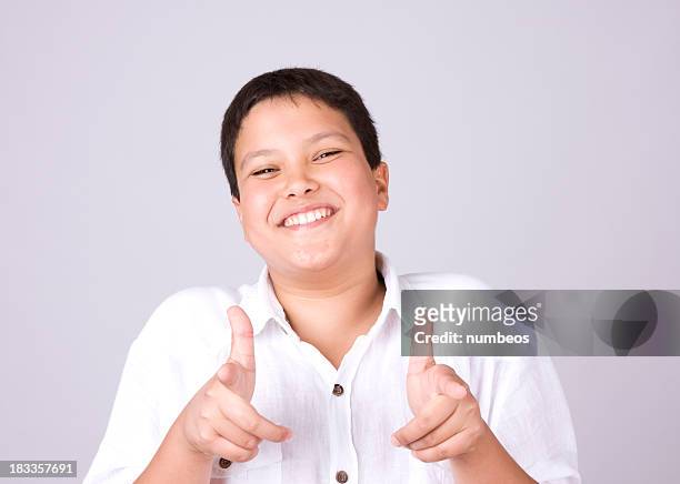 jeune garçon souriant, pointant du doigt - chubby teenager photos et images de collection