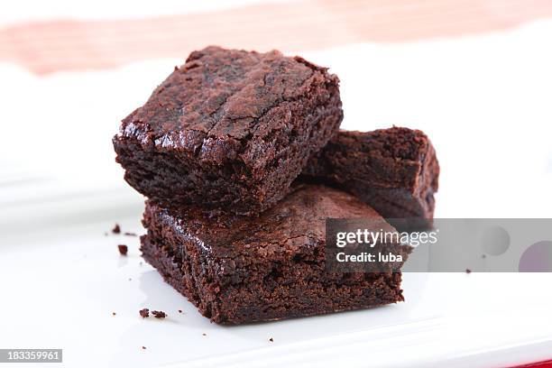 stack of three brownies on white plate - brownie stockfoto's en -beelden