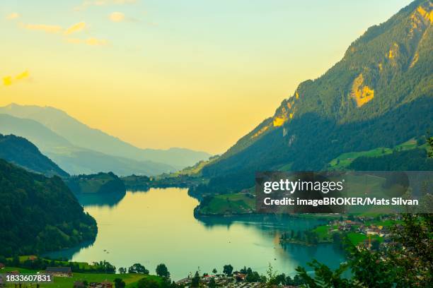 view over lake lungern and village with mountain in sunset in lungern, obvaldo, switzerland - lungern stock-fotos und bilder