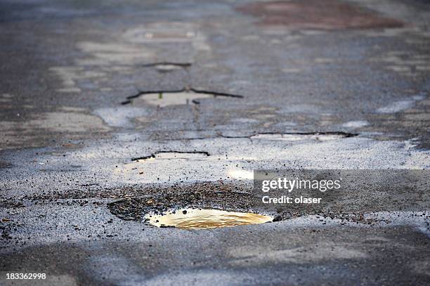 buraco de estrada na estrada de asfalto - pothole in road - fotografias e filmes do acervo