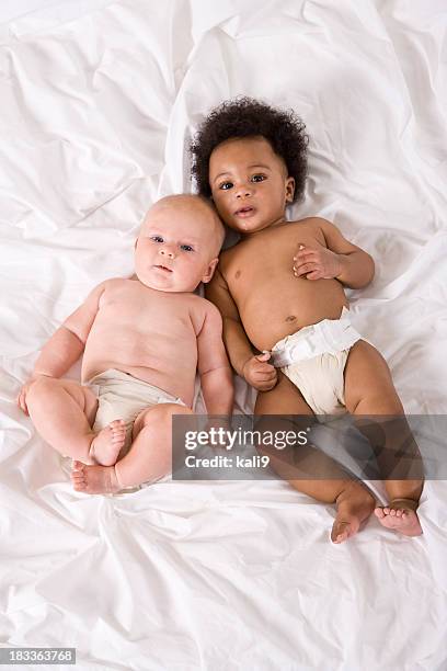 multiracial 赤ちゃん一緒に横になって次の - 9 12 weeks ストックフォトと画像