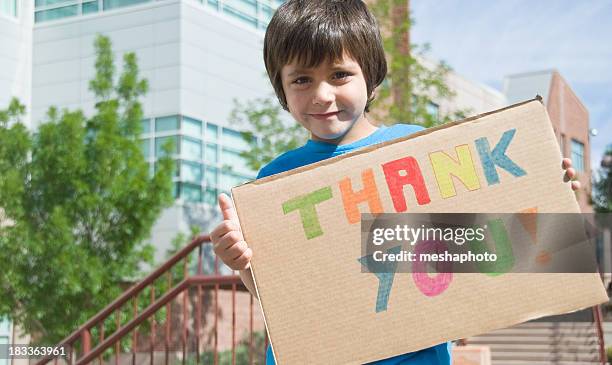 thank you sign held by happy young boy - thank you note stock pictures, royalty-free photos & images