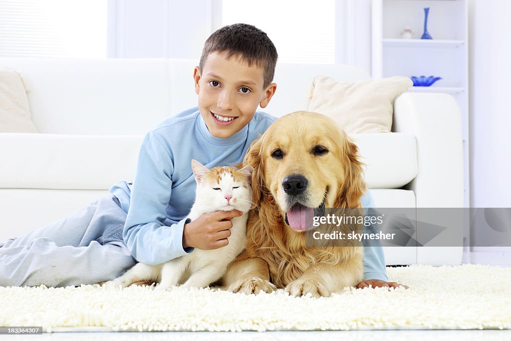 Young boy with dog and a cat.