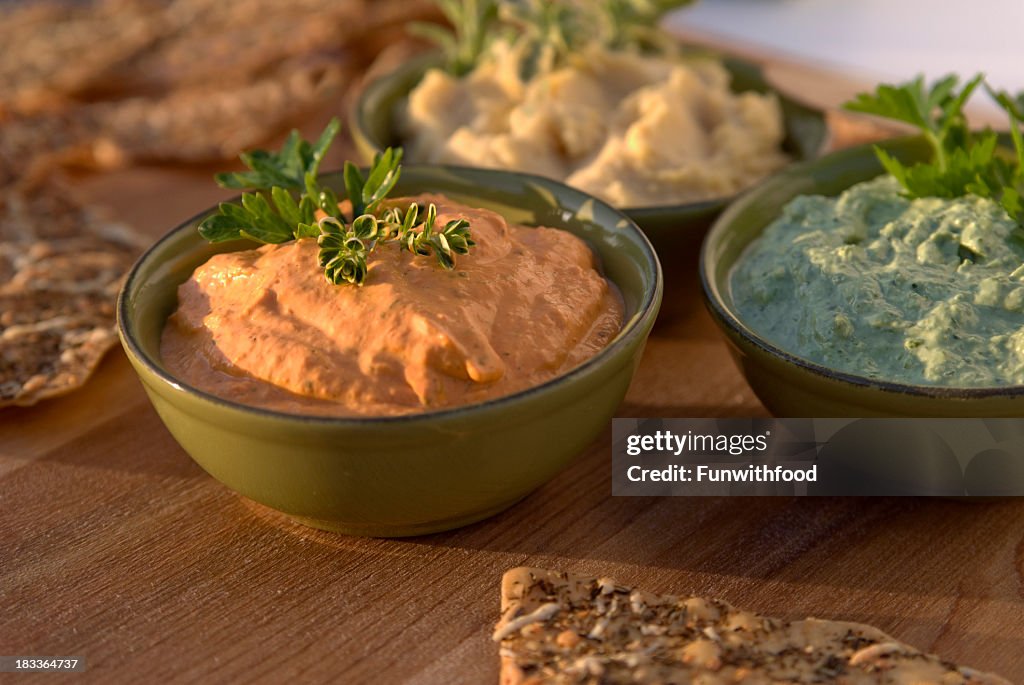 Roasted red bell pepper and vegetable herb hummus on a table