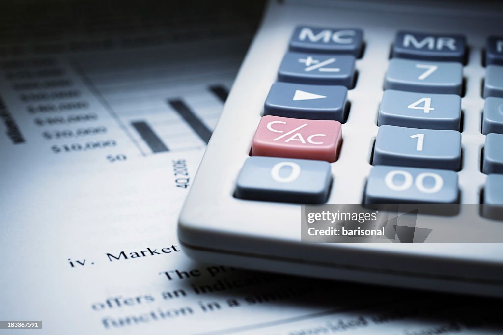 Calculator on chart of financial analysis and graphs