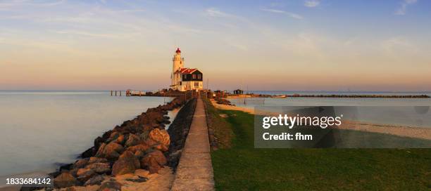 lighthouse paard van marken at sunset (marken, netherlands) - ijsselmeer stock pictures, royalty-free photos & images