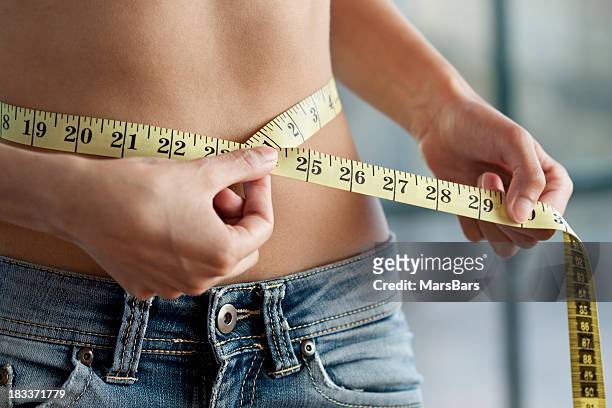 measuring waist close up - slim stock pictures, royalty-free photos & images