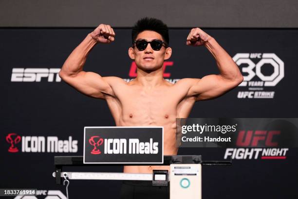 In this handout image provided by UFC, Song Yadong of China poses on the scale during the UFC Fight Night weigh-in at UFC APEX on December 08, 2023...