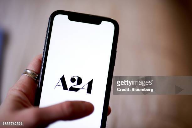 The A24 logo on a smartphone arranged in New York, US, on Friday, Dec. 8, 2023. Independent film company A24 will run its new movies exclusively on...