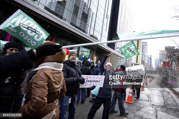 Public sector workers and supporters encourage motorists to honk during a strike outside the Centre hospitalier de l'Universite de Montreal hospital...