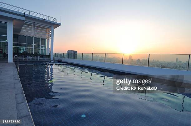 luxury pool auf dem dach bei sonnenuntergang - rooftop pool stock-fotos und bilder