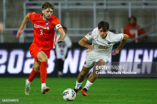 Adam Lundegard of the Clemson Tigers dribbles past Sergio Ors Navarro of the West Virginia Mountaineers during the Division I Men's Soccer Semifinals...
