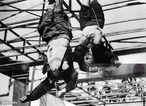 The corpses of Italian dictator Benito Mussolini and his mistress Claretta Petacci are hanged in front of a garage in Milan's Piazzale Loreto, April...