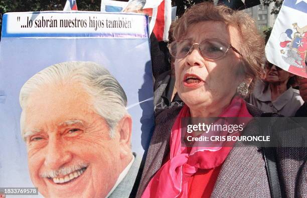 Supporter of Chile's former dictator Gen. Augusto Pinochet holds his portrait during a rally in his support in downtown Santiago 05 May 1999....