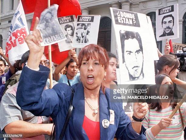 Anti-Pinochet supporters holding portraits of friends and relatives who disappeared during the 1973-1990 Pinochet regime rally in downtown Santiago,...