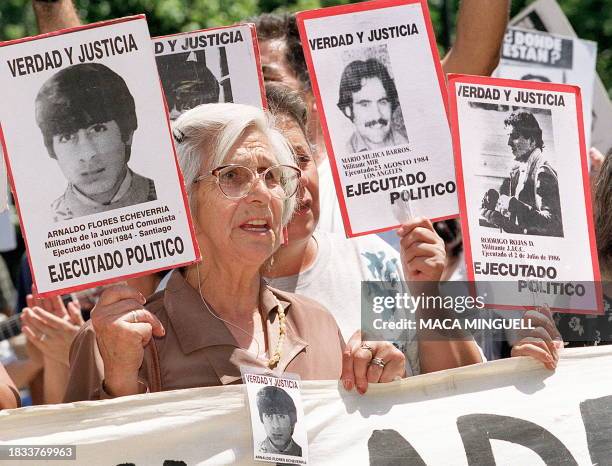 Friends and relatives of people who disappeared during the Chilean military dictatorship hold the pictures of their lost loved ones while rallying...