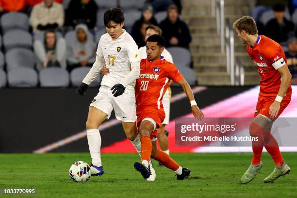 Yutaro Tsukada of the West Virginia Mountaineers and Shawn Smart of the Clemson Tigers battle for the ball during the Division I Men's Soccer...