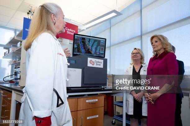 Doctor Noel C Bairey-Merz and Doctor Jennifer Van Eyk explain lab studies to US First Lady Jill Biden during a tour of the Van Eyk lab at...